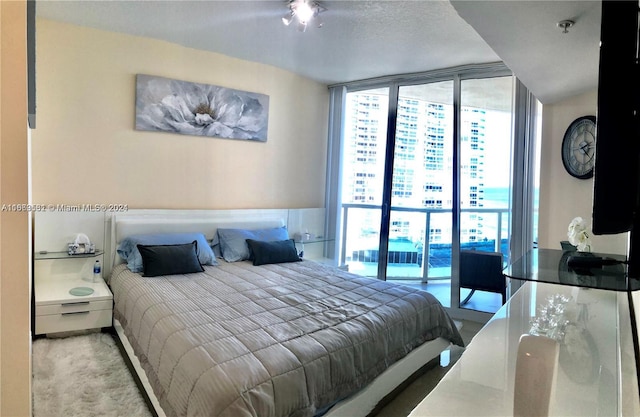 bedroom featuring light colored carpet and a textured ceiling