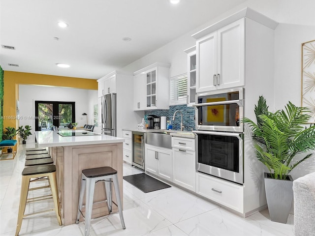 kitchen with beverage cooler, light countertops, and white cabinets