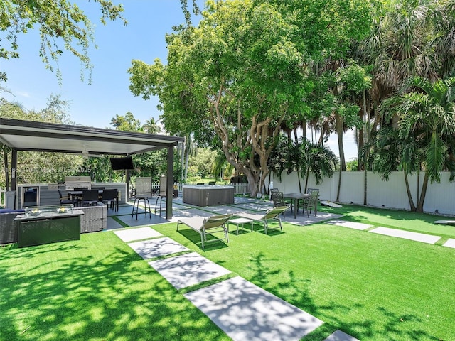 view of yard featuring a hot tub, a patio area, a fenced backyard, and area for grilling