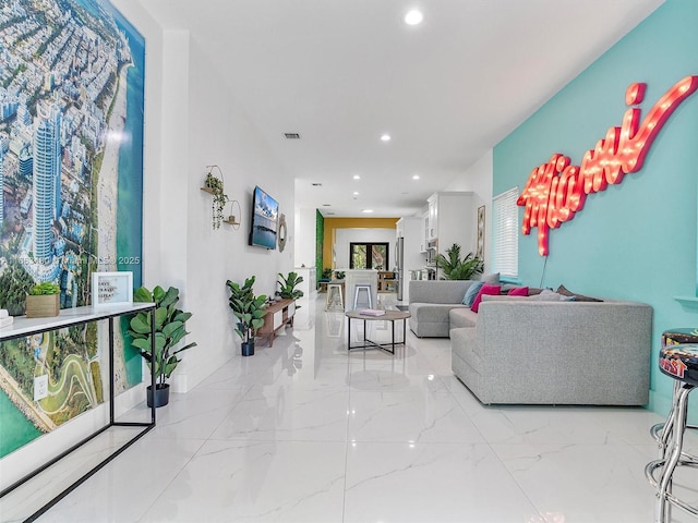 living area with marble finish floor, visible vents, and recessed lighting