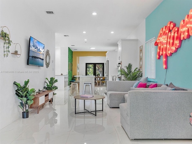 living area featuring marble finish floor, visible vents, and recessed lighting