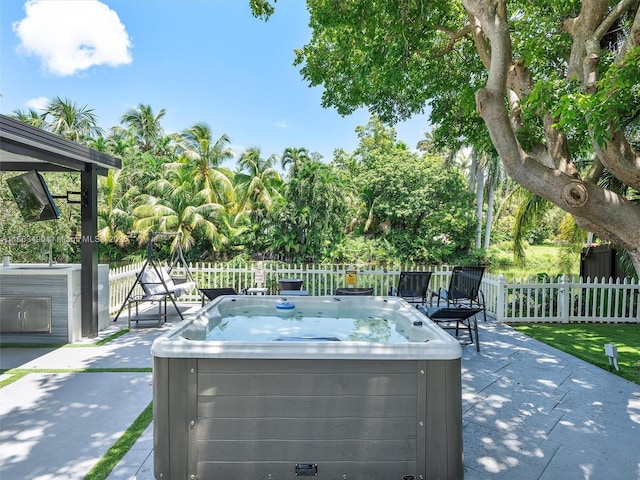 view of patio / terrace featuring fence and a hot tub