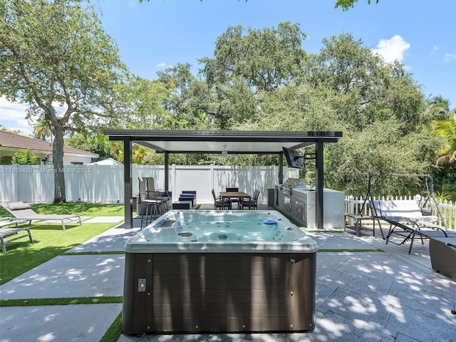 view of patio / terrace with a hot tub, a fenced backyard, and area for grilling