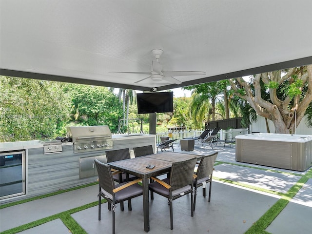 view of patio with outdoor dining area, a hot tub, grilling area, exterior kitchen, and a fenced backyard