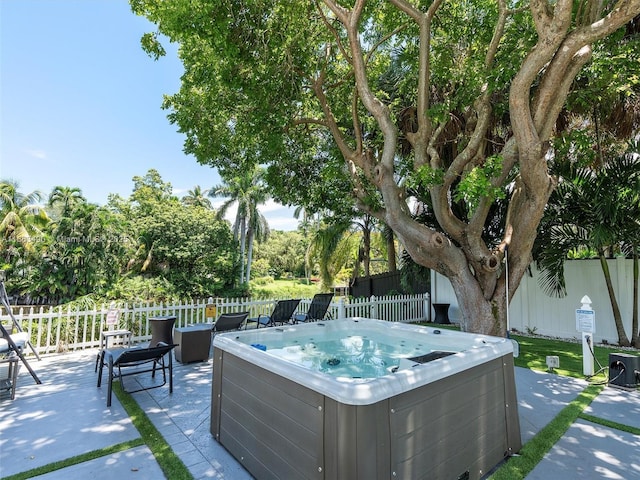 view of patio featuring ac unit, a hot tub, and fence