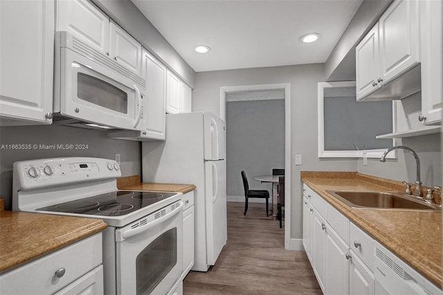 kitchen featuring white cabinetry, sink, white appliances, and light hardwood / wood-style flooring