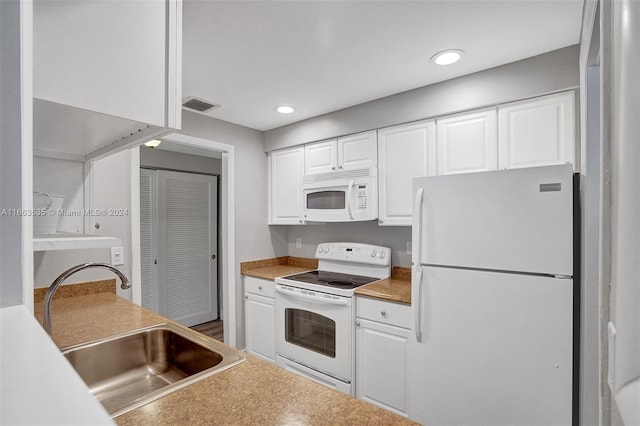 kitchen with sink, white cabinets, and white appliances