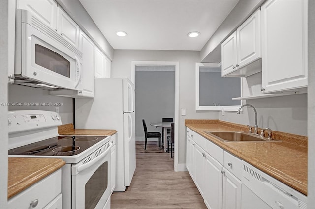 kitchen featuring sink, light hardwood / wood-style flooring, white cabinets, and white appliances