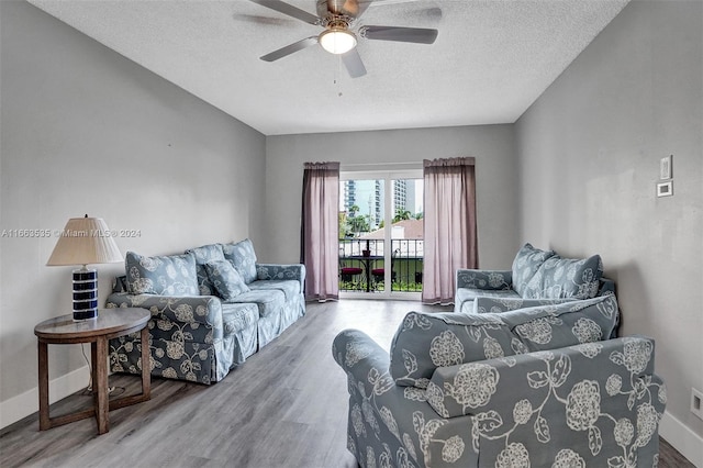 living room with ceiling fan, a textured ceiling, and hardwood / wood-style floors