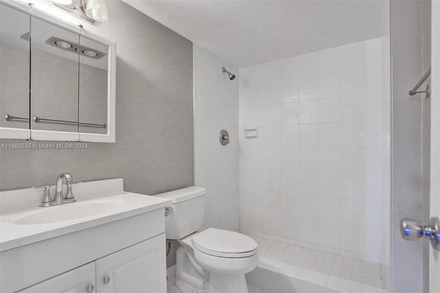 bathroom with toilet, vanity, and tiled shower