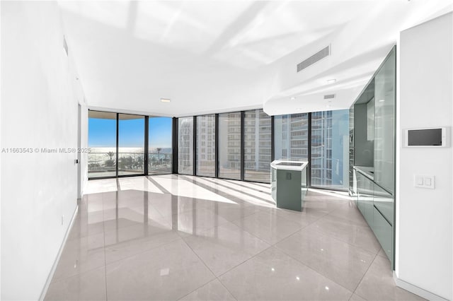 spare room featuring expansive windows and light tile patterned floors