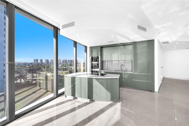 kitchen with a center island, a wealth of natural light, sink, and expansive windows