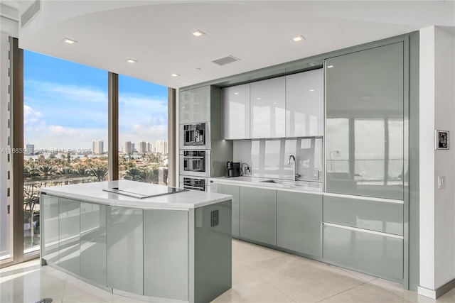 bar with light tile patterned flooring, black electric stovetop, floor to ceiling windows, and stainless steel oven