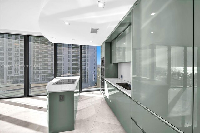 interior space featuring a kitchen island, light tile patterned floors, a healthy amount of sunlight, and a wall of windows