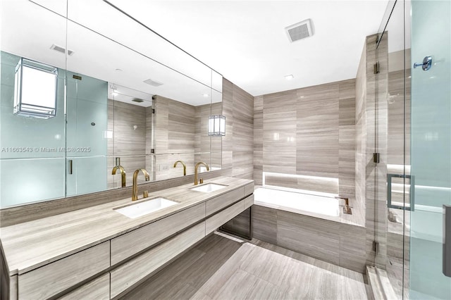 bathroom featuring vanity, separate shower and tub, and tile walls