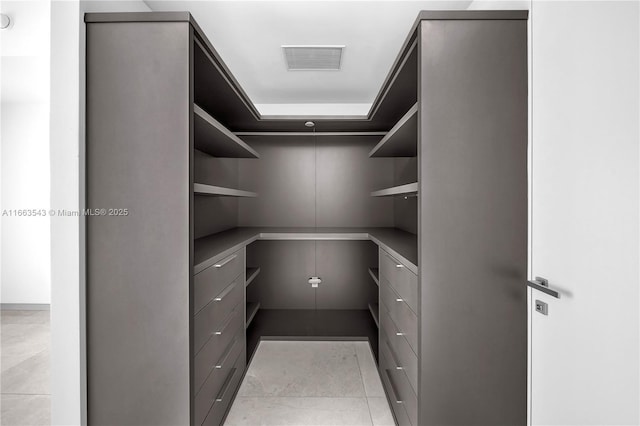 walk in closet featuring light tile patterned floors and built in desk