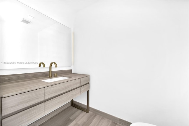 bathroom with hardwood / wood-style floors and vanity