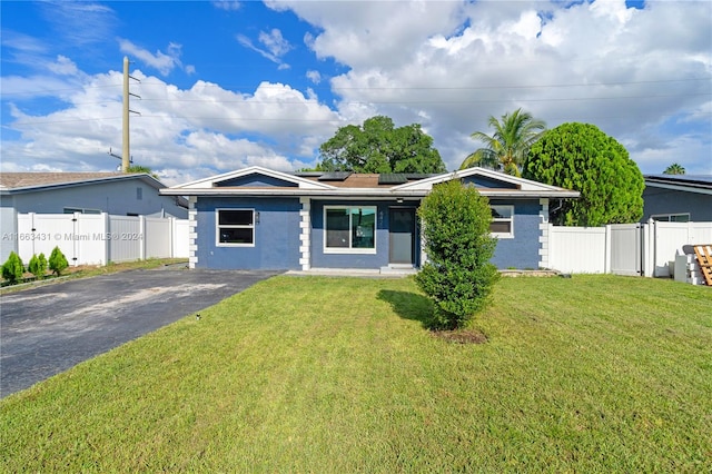 single story home featuring a front lawn and solar panels