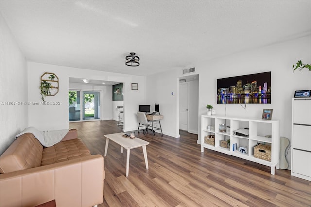 living room with a textured ceiling and wood-type flooring