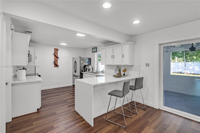 kitchen with white cabinets, backsplash, dark hardwood / wood-style floors, and kitchen peninsula