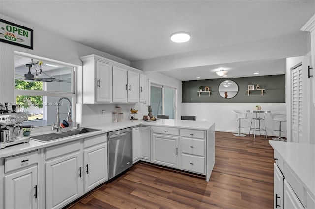 kitchen featuring white cabinets, kitchen peninsula, dishwasher, dark hardwood / wood-style floors, and sink