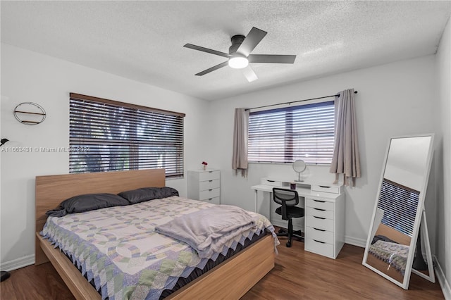 bedroom with a textured ceiling, dark hardwood / wood-style floors, and ceiling fan