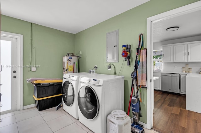 laundry area with electric panel, light hardwood / wood-style flooring, washer and clothes dryer, cabinets, and electric water heater