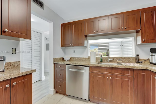 kitchen with light stone countertops, dishwasher, light hardwood / wood-style floors, and sink