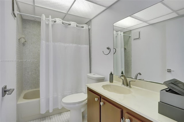 full bathroom featuring a drop ceiling, tile patterned floors, vanity, and toilet