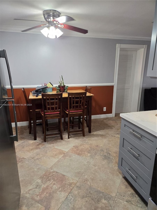 dining area with crown molding and ceiling fan