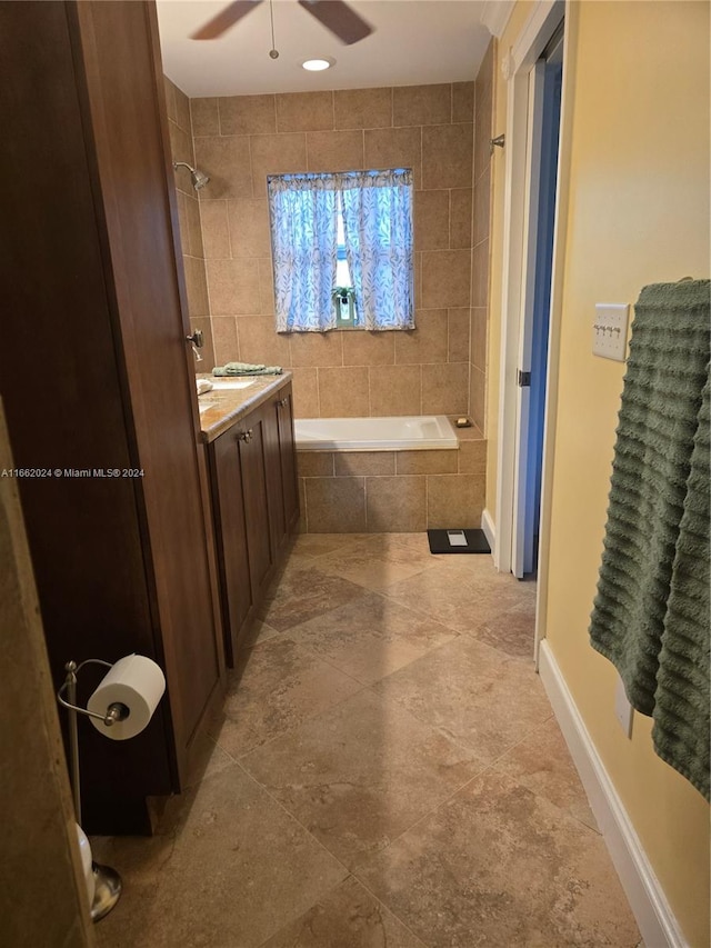 bathroom with vanity, ceiling fan, tile patterned flooring, and tiled shower / bath