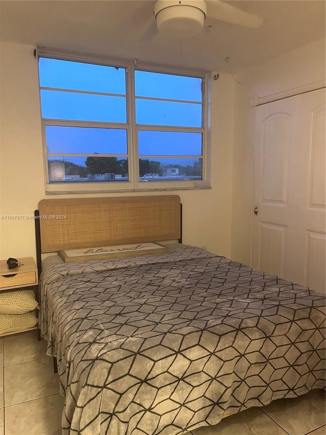 bedroom with a closet, tile patterned flooring, and ceiling fan