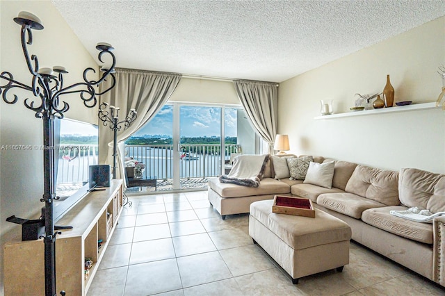 living room featuring a textured ceiling, light tile patterned floors, and a wealth of natural light