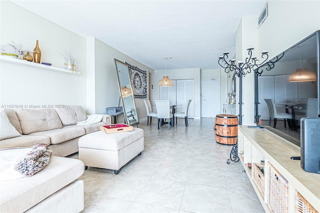 living room with a textured ceiling and light tile patterned flooring