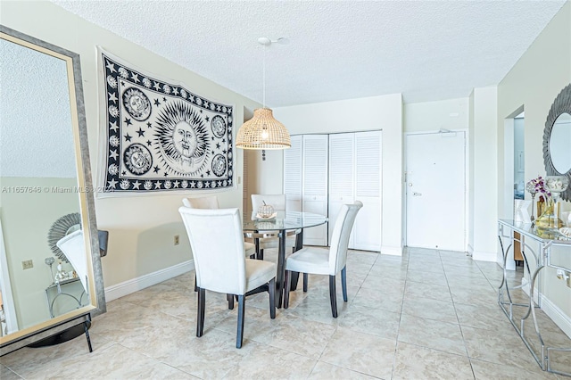 dining area featuring a textured ceiling and light tile patterned floors