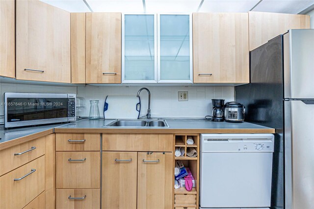 kitchen featuring backsplash, light brown cabinetry, sink, and stainless steel appliances