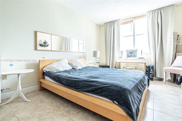 tiled bedroom featuring a textured ceiling