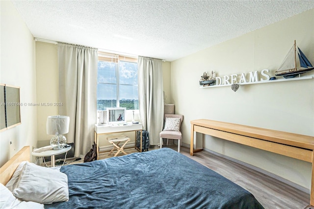 bedroom featuring a textured ceiling and hardwood / wood-style flooring