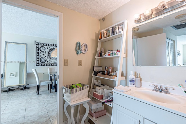 bathroom featuring a textured ceiling, vanity, and tile patterned floors