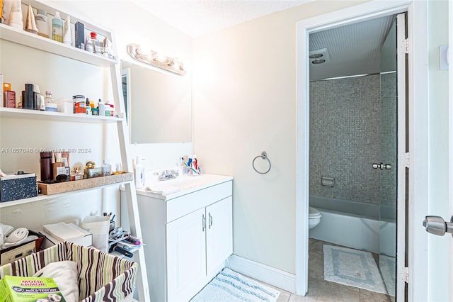 full bathroom with a textured ceiling, tiled shower / bath combo, tile patterned floors, vanity, and toilet