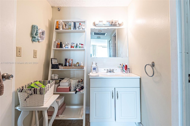 bathroom featuring a textured ceiling and vanity