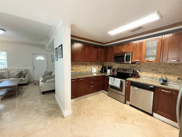 kitchen featuring ornamental molding, stainless steel appliances, backsplash, light stone countertops, and sink