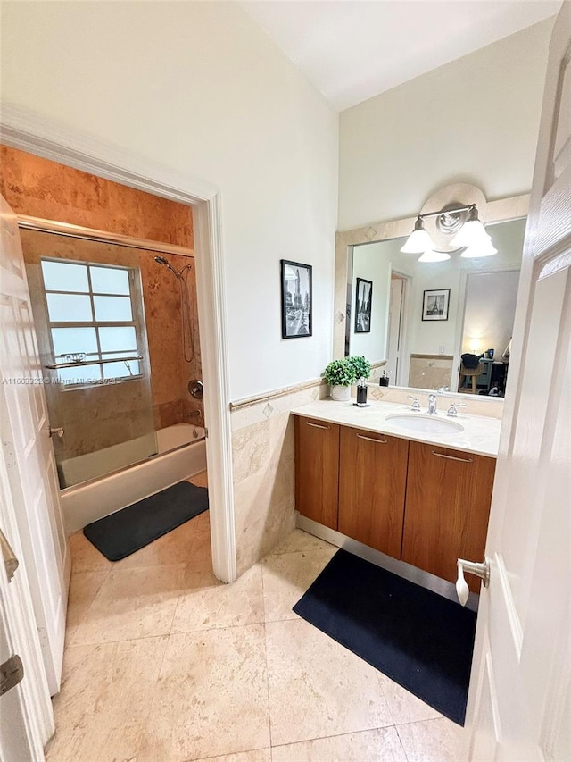 bathroom with tile walls, tiled shower / bath, tile patterned floors, and vanity