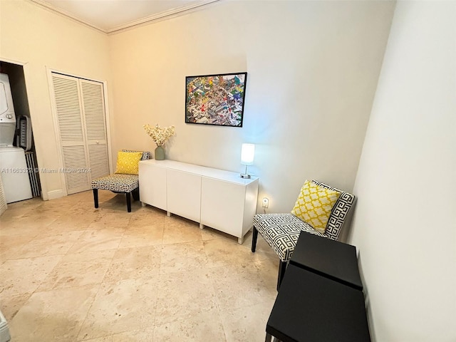 living area with stacked washer and dryer and crown molding