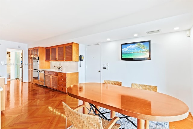 dining space with sink and parquet flooring