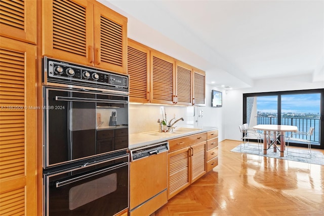 kitchen with dishwashing machine, black double oven, light parquet floors, and sink