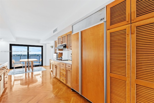 kitchen featuring paneled built in refrigerator and light parquet floors