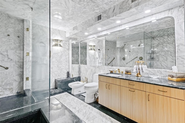 bathroom featuring a bidet, toilet, vanity, a shower with shower door, and tile walls