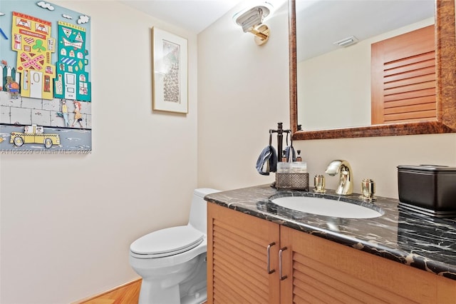 bathroom with hardwood / wood-style flooring, vanity, and toilet