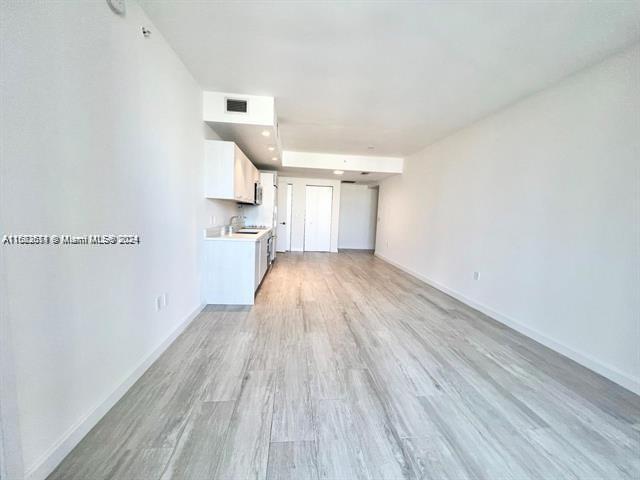45 SW 9th St Unit 3009, Miami, FL 33130 - unfurnished living room with light wood-type flooring and baseboards